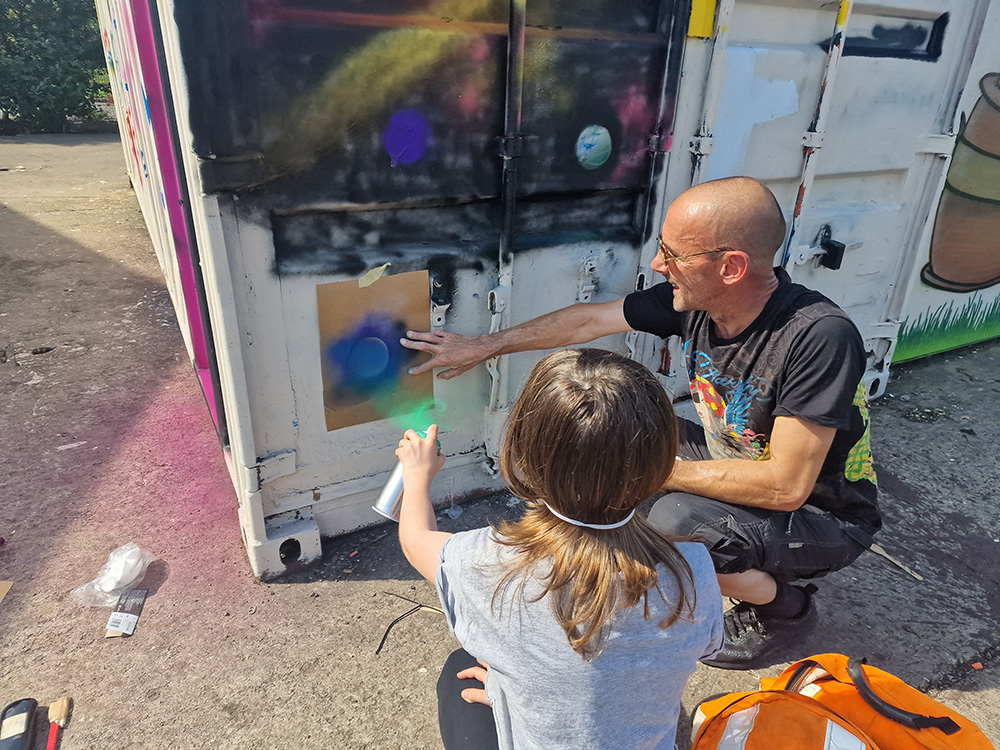 Duncan with a young person practicing graffiti